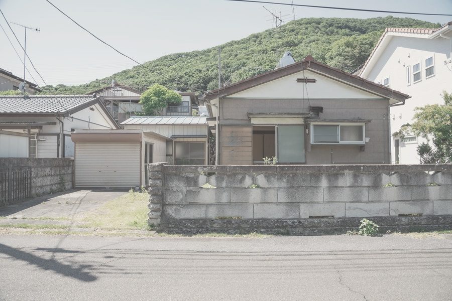 住宅街に建つ平屋の家と、ブロック塀の門まわり