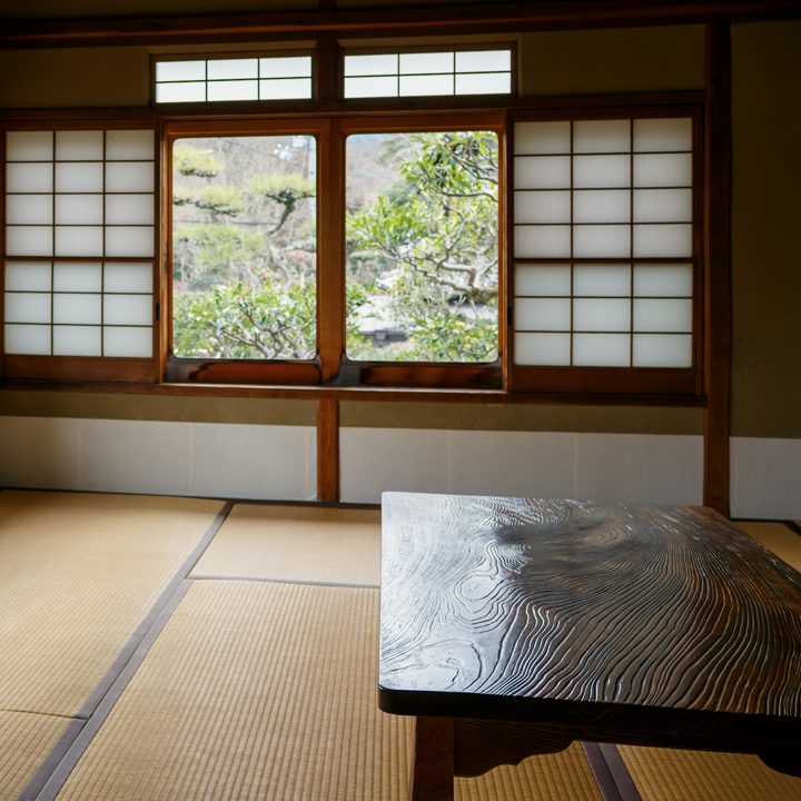 障子と窓から庭の緑が見える、畳の和室と座卓