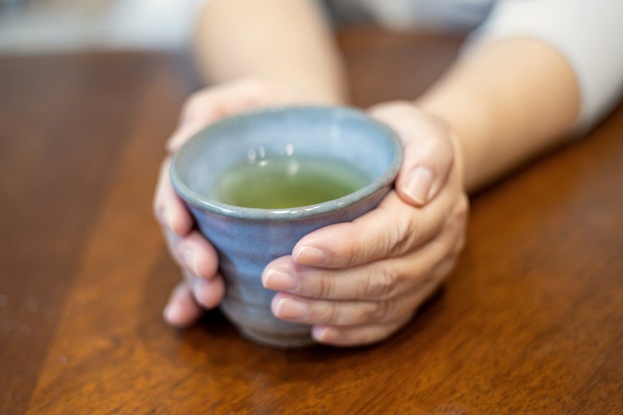 湯のみを両手で包む手元